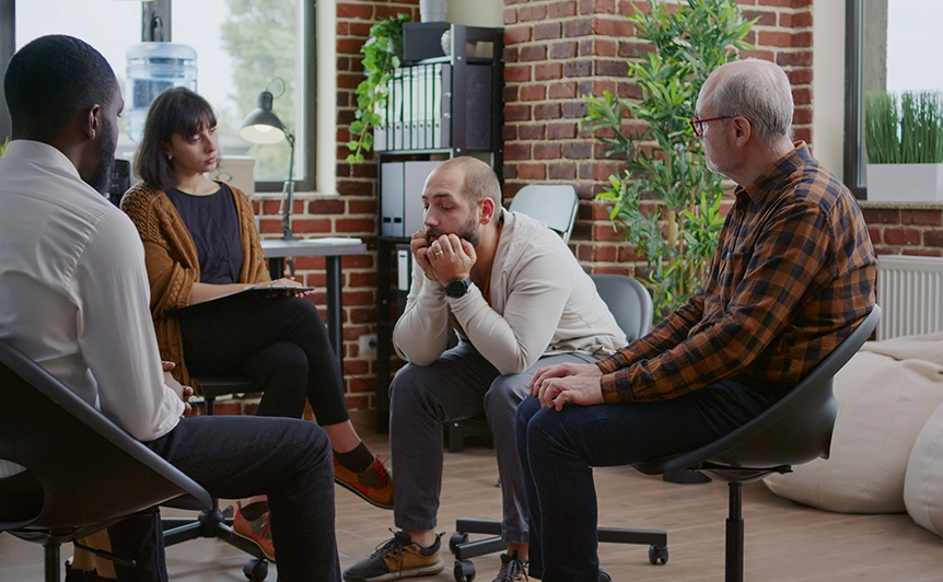 Group Therapy Session with Four Individuals in a Modern Office Setting