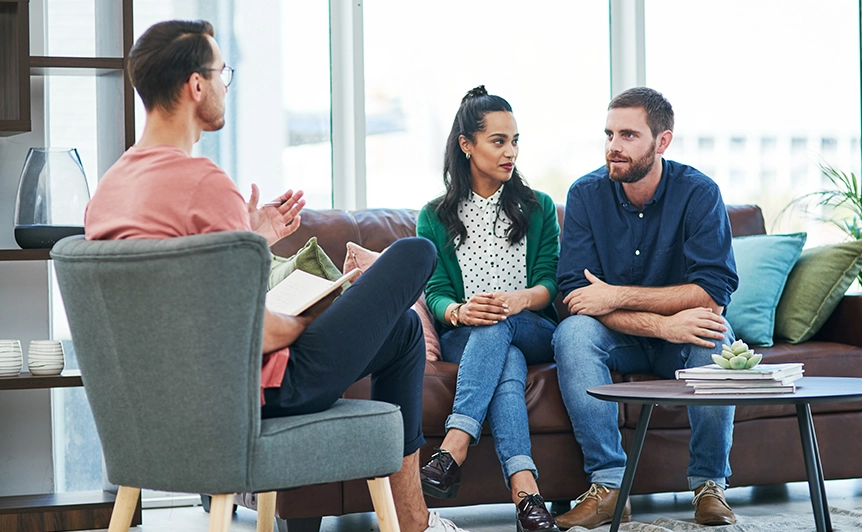 Couple Engaged in Conversation with Counselor in a Comfortable Setting