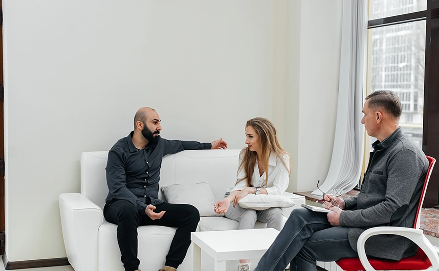Three people having a discussion in a modern counseling office