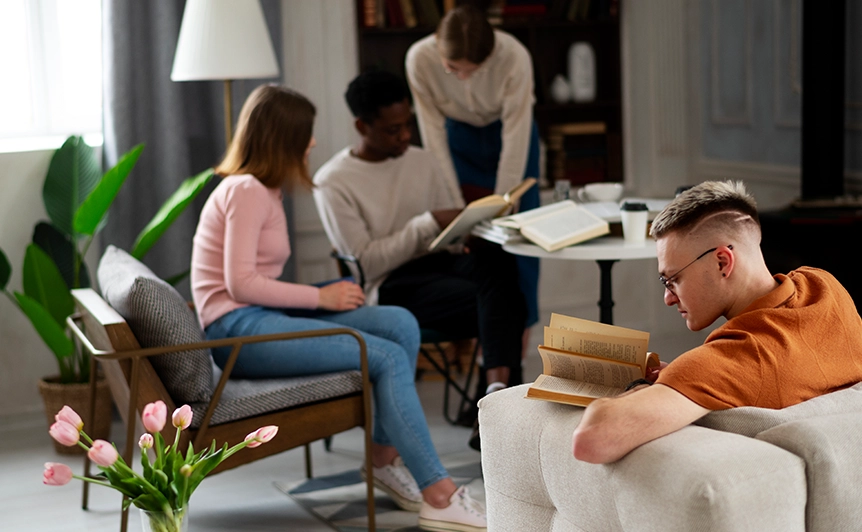 Group of Young Adults Reading and Conversing in a Cozy Living Room