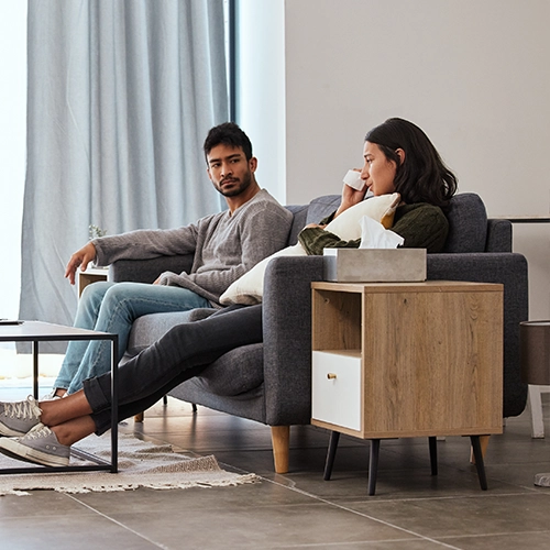 Man and woman sitting on a couch, having a serious conversation.