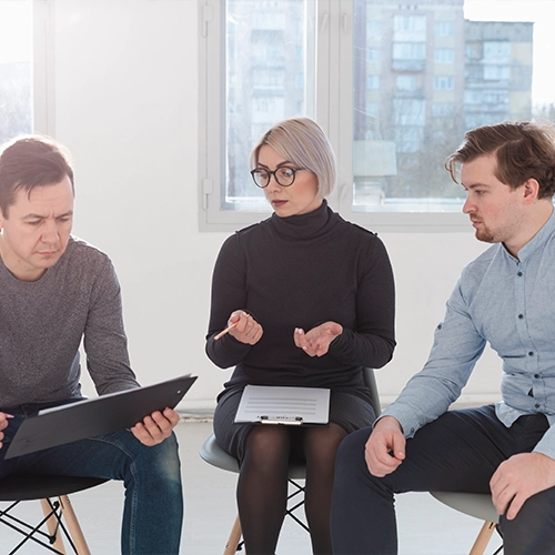 Three people sitting in a room having a discussion.